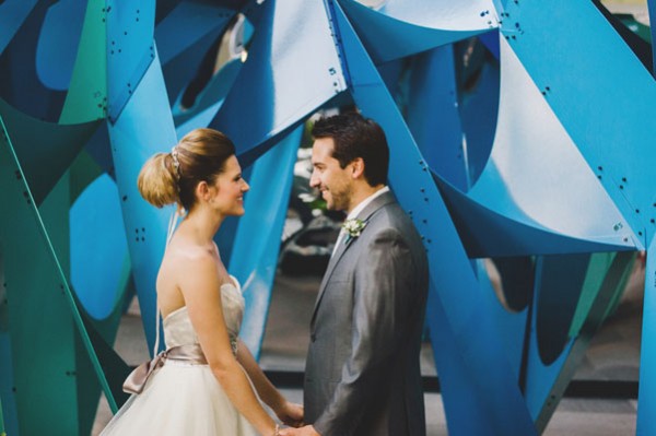 bride and groom in front of art