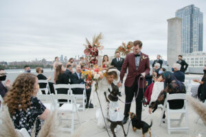 couple walking down the aisle with dogs in manhattan rooftop wedding