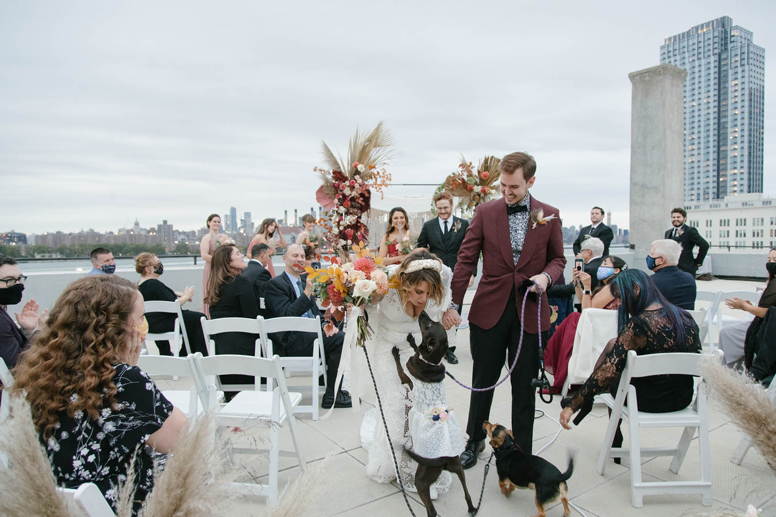 couple walking down the aisle with dogs in manhattan rooftop wedding